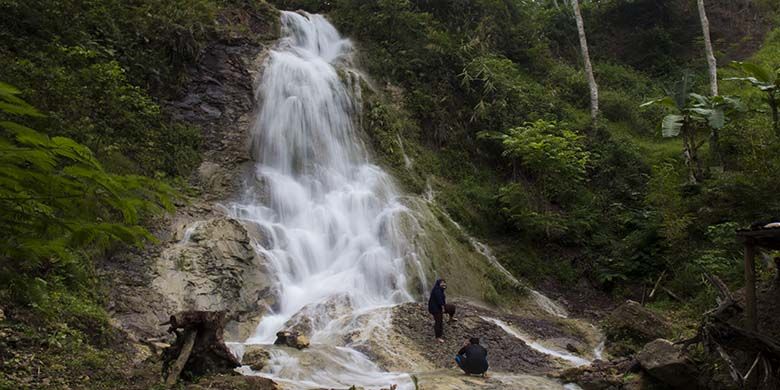 Pengunjung berfoto di depan Air Terjun Kali Miri, kawasan Air Terjun Kembang Soka, Kulon Progo, Yogyakarta.