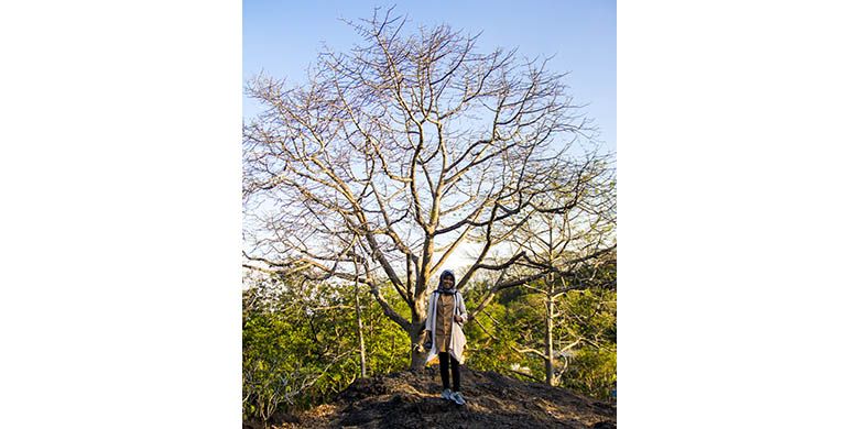 Seorang pengunjung berfoto di depan pohon besar kawasan Gua Selomangleng, Kediri.