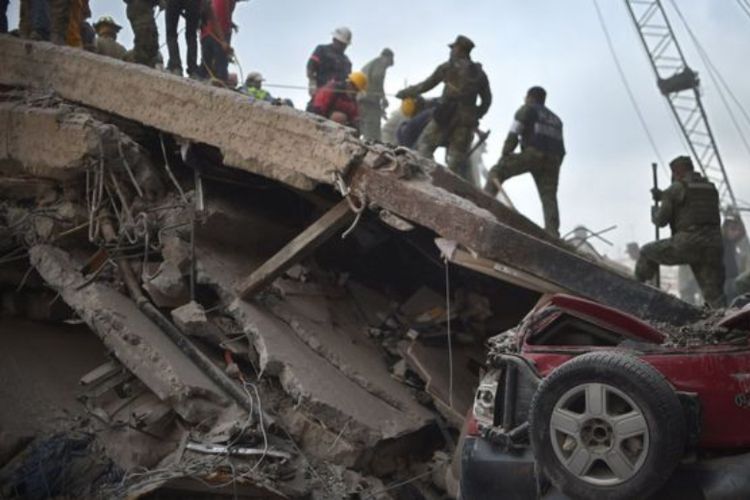 Petugas penyelamat berlomba dengan waktu menyelamatkan korban yang masih hidup di bawah reruntuhan puing akibat gempa di Meksico City, Meksiko.