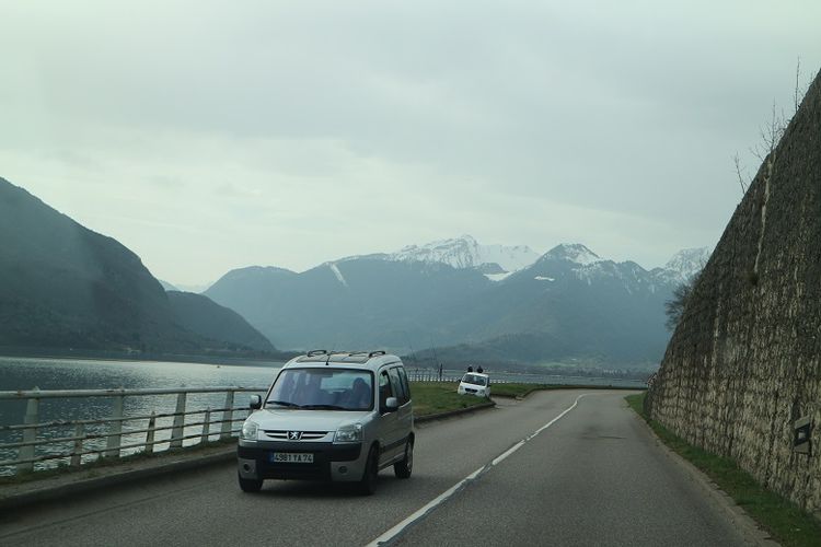 Mobil melintas di sisi Lac d Annecy (Danau Annecy), Perancis dengan pemandangan Pegunungan Alpen, Minggu (8/4/2017). Pegunungan Alpen merupakan jajaran gunung-gunung salju yang melintasi beberapa negara seperti Perancis, Swiss, Italia, dan negara-negara Eropa lainya.