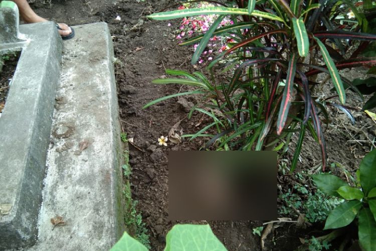 Sebuah kaki yang menyembul dari sebuah makam di pemakaman umum Desa Tegowangi, Kecamatan Plemahan, Kabupaten Kediri, Jawa Timur, Kamis (17/5/2018).

