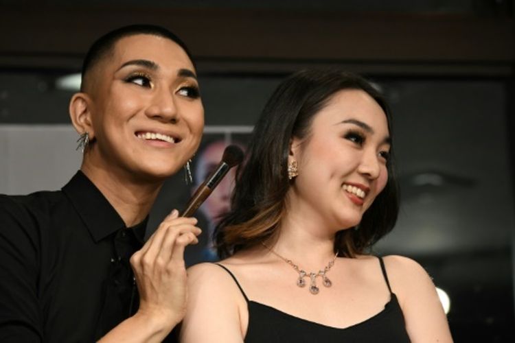 Perias sekaligus biksu Buddha asal Jepang Kodo Nishimura (kiri) berpose dengan model Yuri Hotta (kanan) selama acara di Waseda University di Tokyo. Foto ini diambil pada 19 Juli 2018. (AFP/Toshifumi Kitamura)