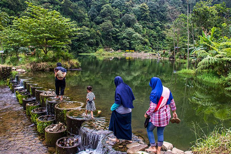 Pengunjung melintas di atas Bendungan Candi Muncar,Girimarto, Wonogiri.