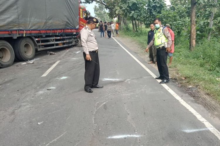 Polisi menunjukkan lokasi kejadian tabrakan antara pick up dan truk tronton di Jalan Raya Desa Wotan, Kecamatan Panceng, Gresik.