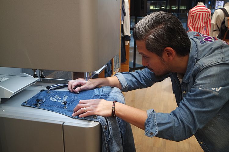 Senior Brand Manager Pepe Jeans London, Olaf Djanuismadi saat mendemonstrasikan penggunaan mesin laser Custom Studio di Pepe Jeans London Grand Indonesia Jakarta, Jumat (23/8).