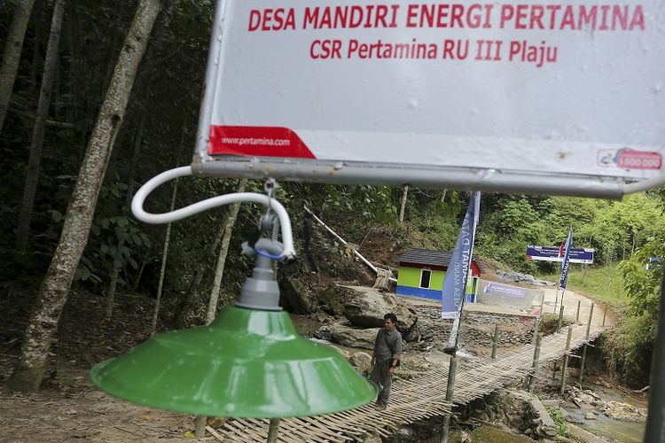 Warga melintasi jembatan di kawasan Pembangkit Listrik Tenaga Mikro Hidro (PLTMH) milik PT Pertamina (persero) Refinery Unit (RU) III Plaju di Desa Merbau, OKU Selatan, Sumatera Selatan, Sabtu (26/8/2017). PT Pertamina (persero) Refinery Unit (RU) III Plaju meresmikan turbin Pembangkit Listrik Tenaga Mikro Hidro (PLTMH) yang menghasilkan daya 10kwh untuk menerangi 33 Kepala Keluarga (KK) yang merupakan program Corporate  Social Responsibility (CSR). 