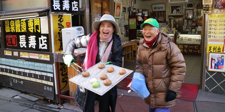 Wisatawan berpura-pura sebagai penjual bakpao dengan menawarkan bakpao gratis sebelum memasuki Sai No Kawara Park di Kusatsu Onsen, Prefektur Gunma, Jepang, Jumat (2/12/2016).