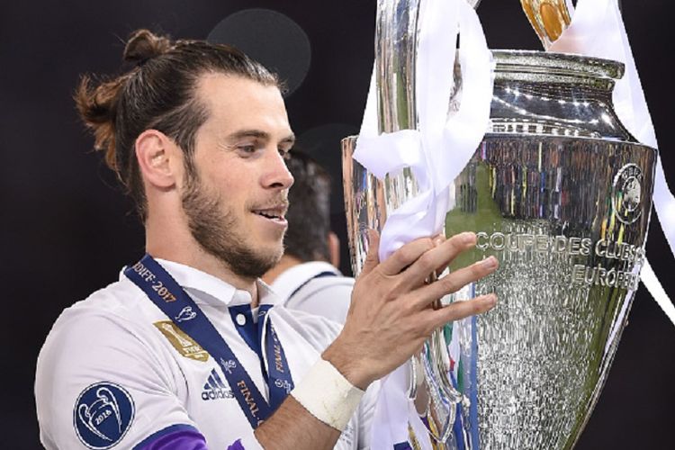 Gareth Bale mengangkat trofi Liga Champions seusai Real Madrid menang atas Juventus pada laga final di Stadion Millenium, Cardiff, Sabtu (3/6/2017). 