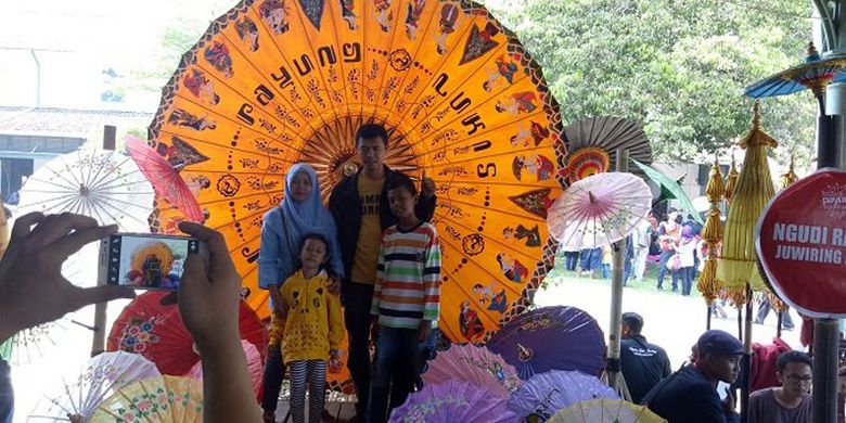 Satu keluarga berfoto di stan Payung Thailand di Festival Payung 2017 di Pura Mangkunegaran Solo, Jawa Tengah, Minggu (17/9/2017).
