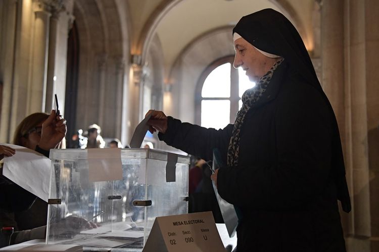Seorang biarawati memasukkan kertas suara ke dalam kotak saat pemilu di Catalonia (21/12/2017). Dalam pemilu yang digelar pasca-pembekuan status otonomi Catalonia oleh Spanyol, pro-kemerdekaan mengklaim suara mayoritas.