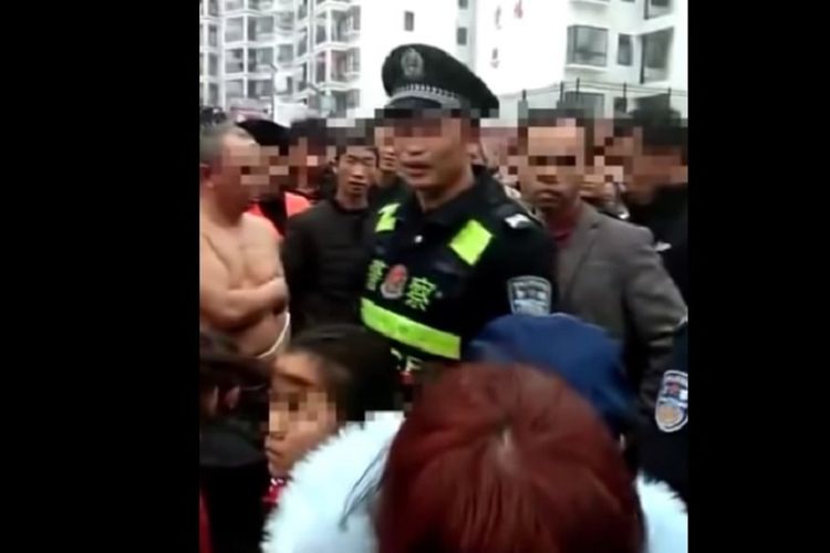 Potongan video yang viral memperlihatkan polisi berusaha menenangkan massa dengan seorang pria berdiri telanjang karena diikat setelah istrinya memergokinya berduaan bersama selingkuhan di China.