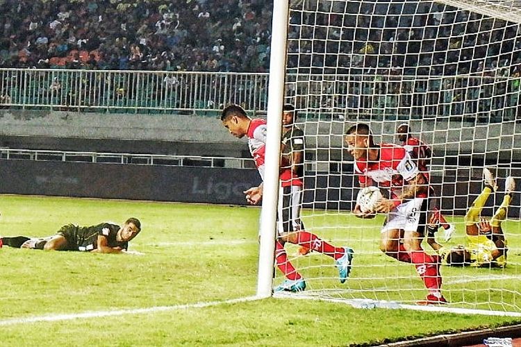 Striker Madura United, Aleksandar Rakic, memungut bola setelah berhasil menjebol gawang PS Tira Persikabo pada laga Liga 1 di Stadion Pakansari, Cibinong, Bogor, Jumat (12/7/2019).