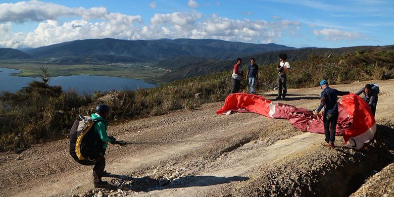 Tim paralayang Mapala UI dalam Ekspedisi Bumi Cenderawasih tengah melakukan persiapan lepas landas melintasi Danau Anggi Gida dan Anggi Giji dari Bukit Kombrey, Distrik Anggi, Kabupaten Pegunungan Arfak, Papua Barat, Jumat (17/8/2018) sore. Danau Anggi Gida dan Anggi Giji merupakan obyek wisata yang berpotensi untuk dikembangkan wisata minat khusus seperti paralayang.(ARSIP MAPALA UI) Artikel ini telah tayang di Kompas.com dengan judul 