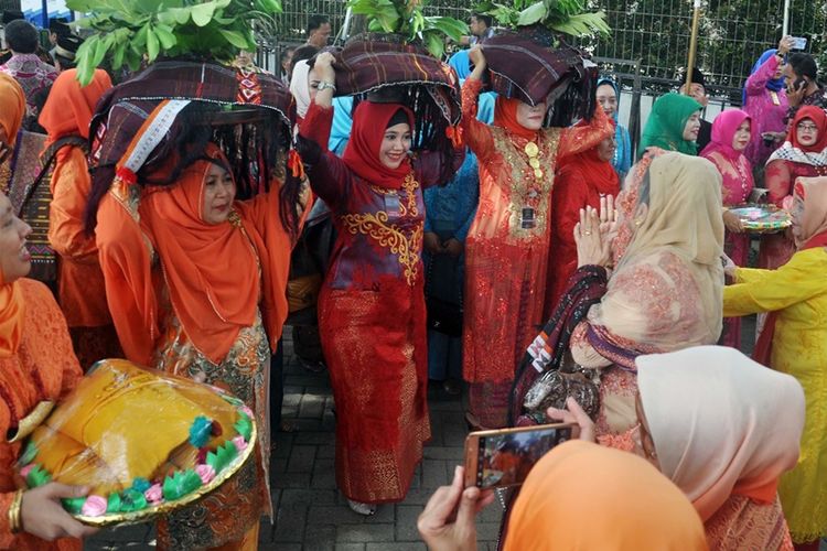 Sejumlah kerabat dan keluarga marga Siregar membawa persembahan Itak Godang ketika mengikuti ngunduh mantu pernikahan Kahiyang Ayu-Bobby Nasution, di Medan, Sumatra Utara, Jumat (24/11). Itak Godang adalah barang bawaan berbungkus kain ulos warna hitam dan merah yang dibawa oleh para ibu pihak keluarga Siregar. Bungkusan ini berisi aneka makanan khas suku Mandailing untuk persembahan khusus dari pihak keluarga marga Siregar kepada pihak pengantin. 