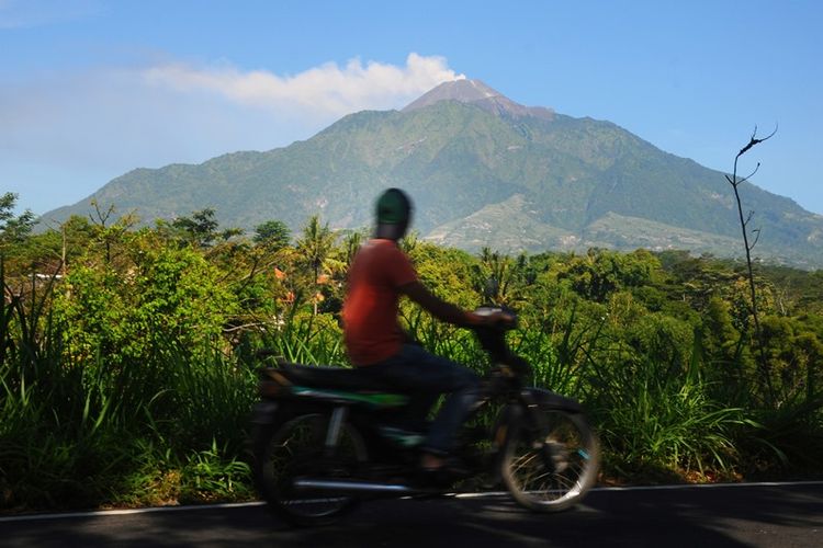 Pengendara melintas di jalur Boyolali-Magelang berlatar belakang letusan freatik Gunung Merapi di Cepogo, Boyolali, Jawa Tengah, Jumat (11/5). Berdasarkan data Badan Nasional Penanggulangan Bencana (BNPB) terjadi letusan freatik Gunung Merapi disertai suara gemuruh dengan tekanan sedang hingga kuat dan tinggi kolom 5.500 meter dari puncak kawah pada pukul 07.32 WIB. 