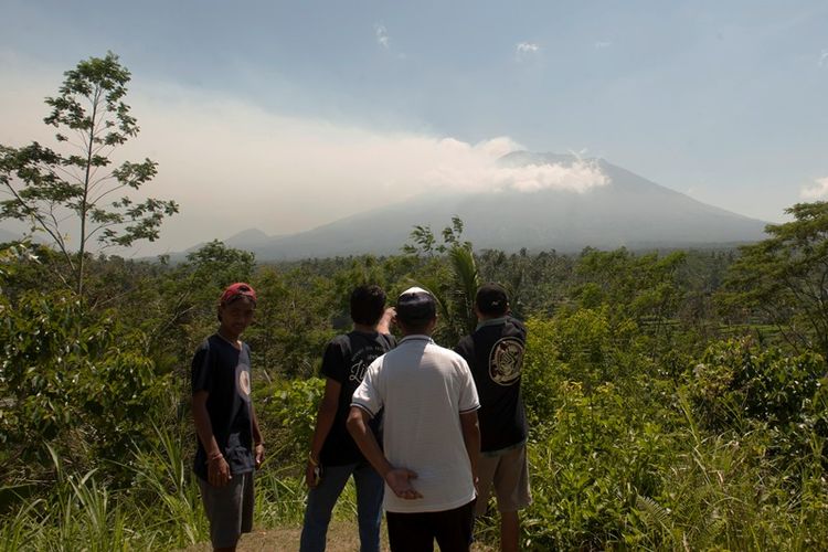 Warga memotret asap yang mulai mengepul dari kawah Gunung Agung dari Pos Pemantauan Desa Rendang, Karangasem, Bali, Selasa (19/9). Petugas pos pemantauan Gunung Agung telah mencatat tingkat kegempaan meningkat drastis dari 180 kali menjadi 366 kali dalam 24 jam terakhir. 