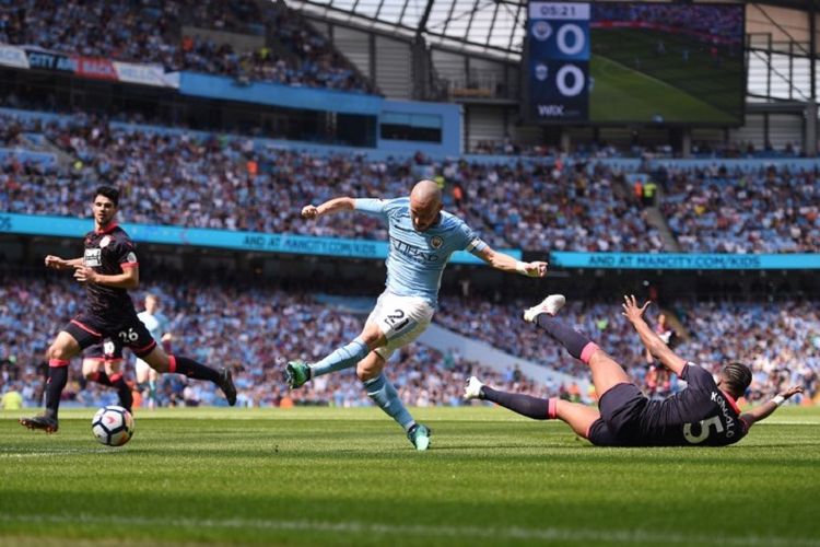 Gelandang Manchester City, David Silva, melepas tembakan ke arah gawang Huddersfield Town pada pertandingan Premier League di Stadion Etihad, Minggu (6/5/2018).