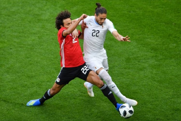 Amr Warda mencoba merebut bola yang dalam penguasaan Martin Caceres pada laga Mesir vs Uruguay di Yekaterinburg Arena, 15 Juni 2018. 