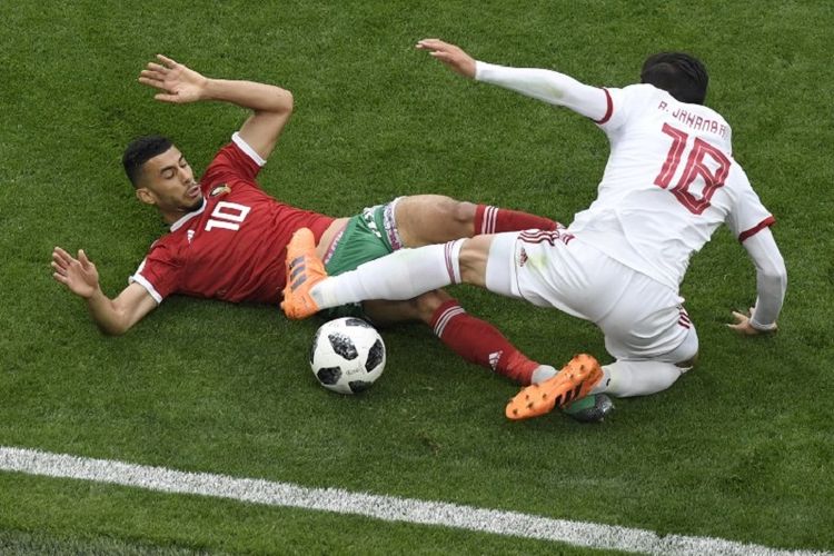 Younes Belhanda dan Alireza Jahanbakhsh memperebutkan bola pada pertandingan Piala Dunia 2018, Maroko vs Iran, di St. Petersburg, 15 Juni 2018. 