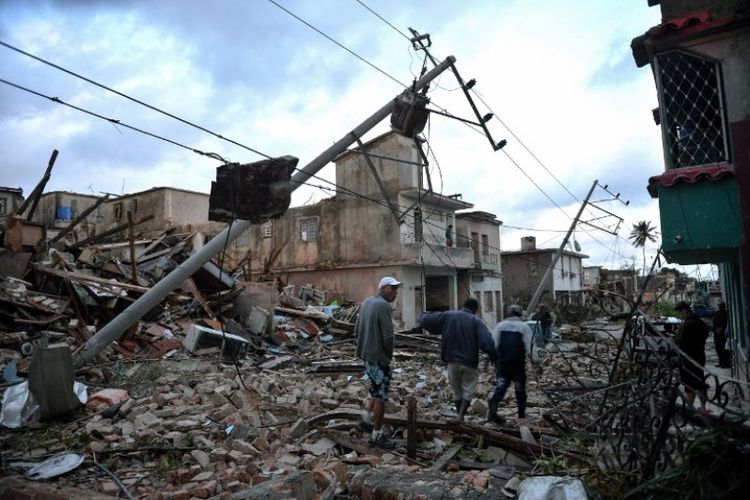 Penduduk berjalan di antara puing-puing bangunan yang tersisa setelah berlalunya tornado di Havana, Kuba, pada Senin (28/1/2019). (AFP/YAMIL LAGE)