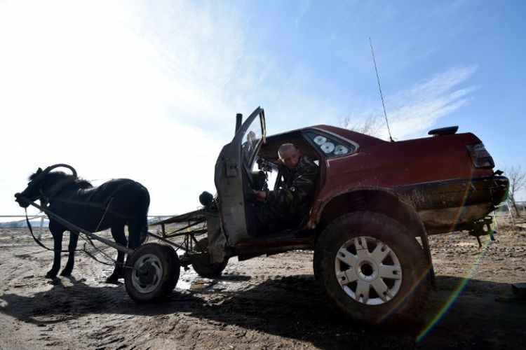 Petani bernama Alexei Usikov masuk ke mobilnya yang ditarik kuda di desa atau horse-mobile Slabodka, Knyazhitsy, wilayah Mogilev, Belarus, pada Senin (18/3/2019). (AFP/SERGEI GAPON)