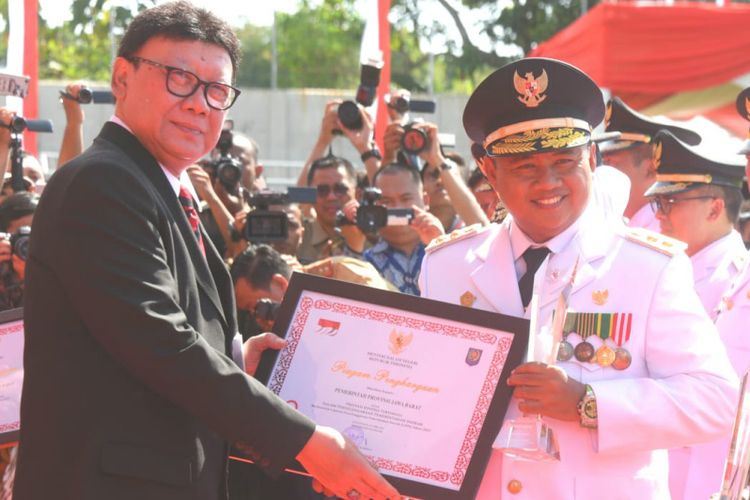 Wakil Gubernur Jawa Barat UU Ruzhanul Ulum menerima penghargaan sebagai Pemerintah Terbaik dari Menteri Dalam Negeri Tjahjo Kumolo saat upacara peringatan ke-23 Hari Otonomi Daerah di Stadion Diponegoro, Kabupaten Banyumas, Jawa Tengah, Kamis (25/4/2019).
