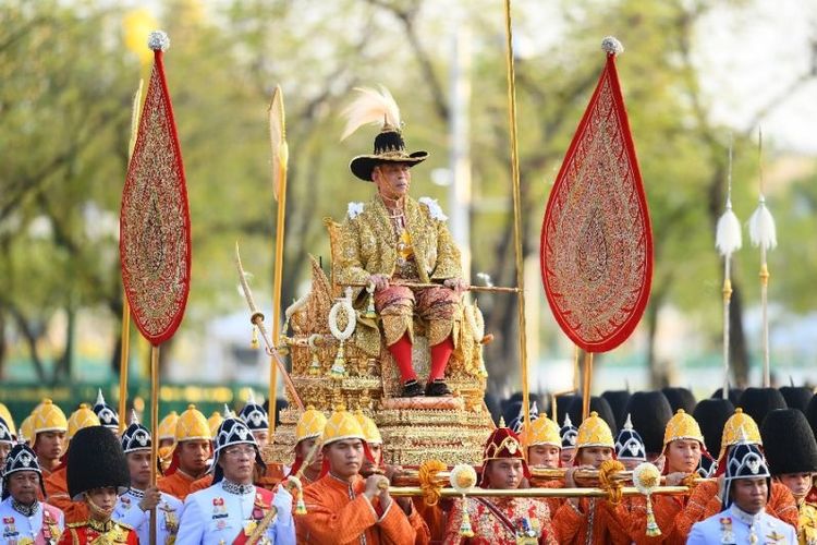 Raja Thailand Maha Vajiralongkorn dibawa melewati jalanan Bangkok dalam prosesi kerajaan hari kedua, Minggu (5/5/2019). (AFP/MANAN VATSYAYANA)