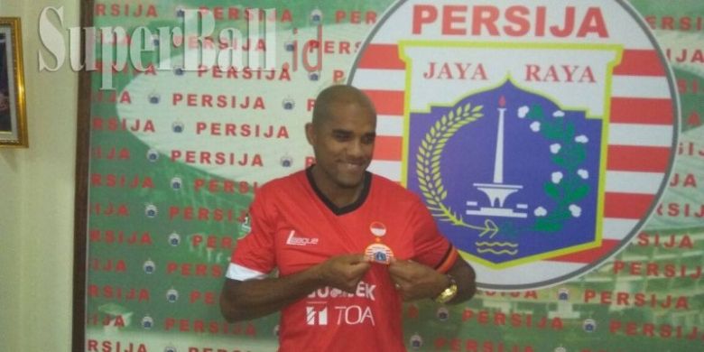 Pemain baru Persija Jakarta, Reinaldo Elias da Costa, berpose menggunakan kostum Persija.