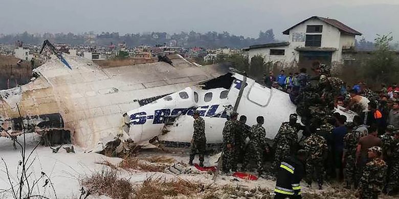Tim penyelamat dan tentara berada di sekitar pesawat milik maskapai US-Bangla yang mengalami kecelakaan di bandara Tribuvhan, Kathmandu, Nepal, Senin (12/3/2018).