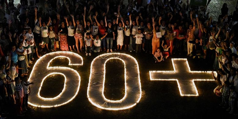 Masyarakat menyalakan lilin dan membentuk simbol 60+ dalam  kampanye lingkungan Earth Hour di Cali, Kolombia, Sabtu (24/3/2018). (AFP/Luis Robayo)

