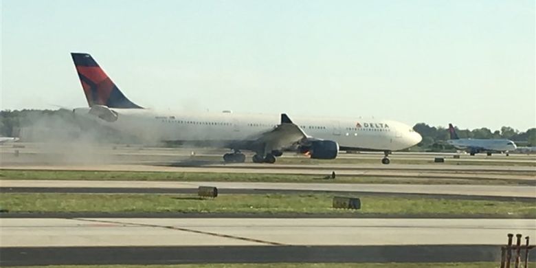 Sebuah gambar yang memperlihatkan salah satu mesin pesawat Delta Airlines berasap, dan membuat pesawat itu mendarat darurat di Bandara Atlanta Rabu (18/4/2018).