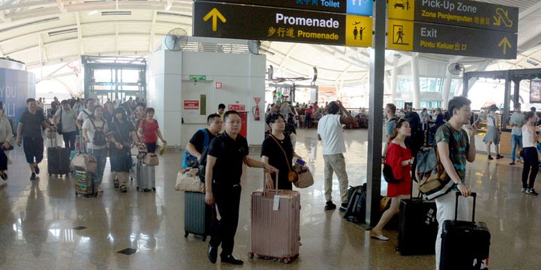 Sejumlah penumpang beristirahat menunggu jadwal penerbangan di Bandara Ngurah Rai, Bali, Jumat (29/6/2018). 