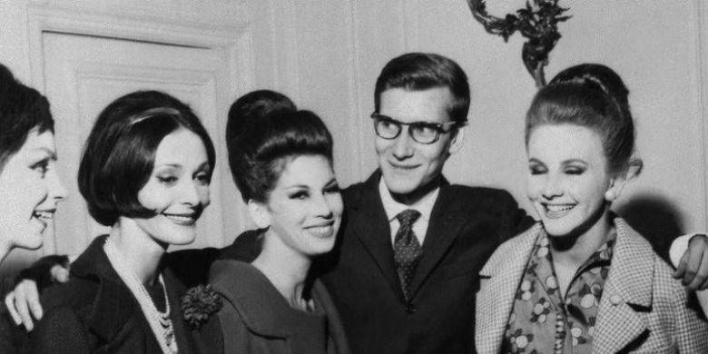 Perancang busana Perancis Yves Saint-Laurent berpose dengan modelnya, usai menampilkan koleksi Christian Dior pada Juli 1959. (AFP)