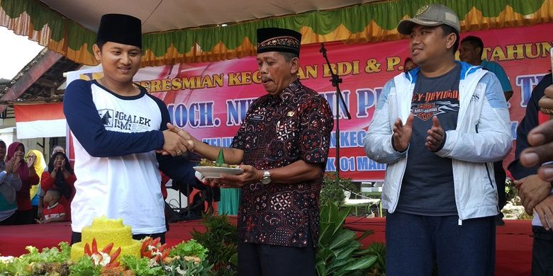 Plt bupati Trenggalek Mochamad Nur Arifin memotong tumpeng dan diberikan kepada kepala kelurahan Tamanan, dalam kegiatan meresmikan kegiatan pembangunan BDI dan P-APBD 2018, Jumat (01/03/2019). 