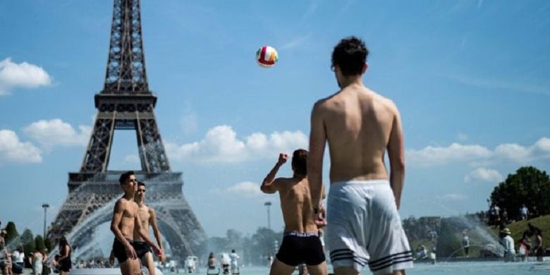 Sekelompok pemuda bermain voli di sebuah kolam air mancur di Paris, Perancis.