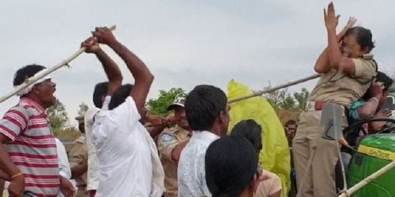 Salah satu penduduk di Telangana, India, memukul polisi perempuan dengan tongkat ketika terjadi aksi protes.