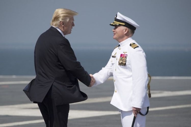 Presiden AS Donald Trump disambut komandan kapal induk Gerald R Ford, Kapten Rick McCormack di dek pendaratan kapal baru tersebut.