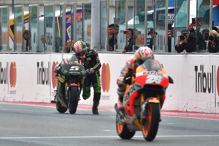 Pebalap Monster Yamaha Tech 3, Johann Zarco (kiri), mendorong motor untuk melewati garis finis pada balapan GP San Marino di Sirkuit Marco Simoncelli Misano, 10 September 2017.
