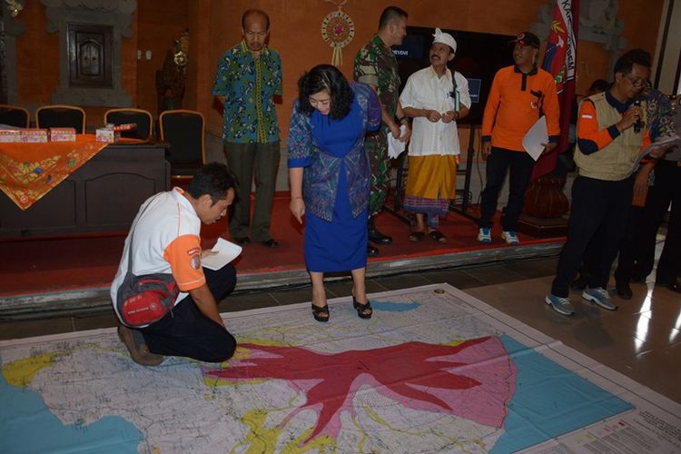 Bupati Karangasem, I Gusti Ayu Mas Sumatri (kedua kiri) berbincang dengan petugas BPBD saat rapat koordinasi siaga bencana Gunung Agung di Karangasem, Bali, Minggu (17/9). Pemkab Karangasem mendata sedikitnya 22 desa yang berdekatan dengan Gunung Agung serta kemungkinan rawan terkena dampak jika terjadi letusan. 