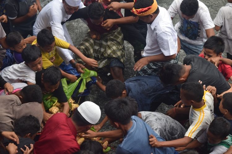 Puluhan anak kecil berebutan mencari uang di atas batu dalam ritual Tradisi Adat Batu Poaro yang dilaksanakan pemerintah Kota Baubau Sulawesi Tenggara 