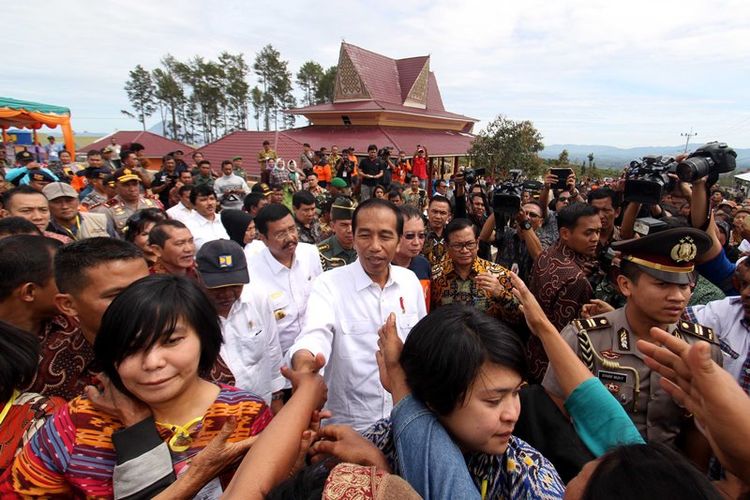 Presiden Joko Widodo menyapa warga saat tiba di kawasan perumahan relokasi pengungsi Gunung Sinabung di Desa Siosar, Karo, Sumatera Utara, Sabtu (14/10). Perumahan untuk relokasi pengungsi Sinabung yang dipersiapkan sebanyak 370 rumah baru itu akhirnya selesai dan telah dihuni oleh para pengungsi.