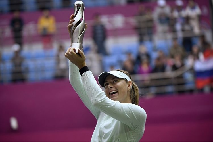 Petenis Rusia, Maria Sharapova, mengangkat trofi kemenangan setelah menjuarai turnamen Tianjin Terbuka berkat kemenangan atas pemain muda Belarus, Aryna Sabalenka, Minggu (15/10/2017).