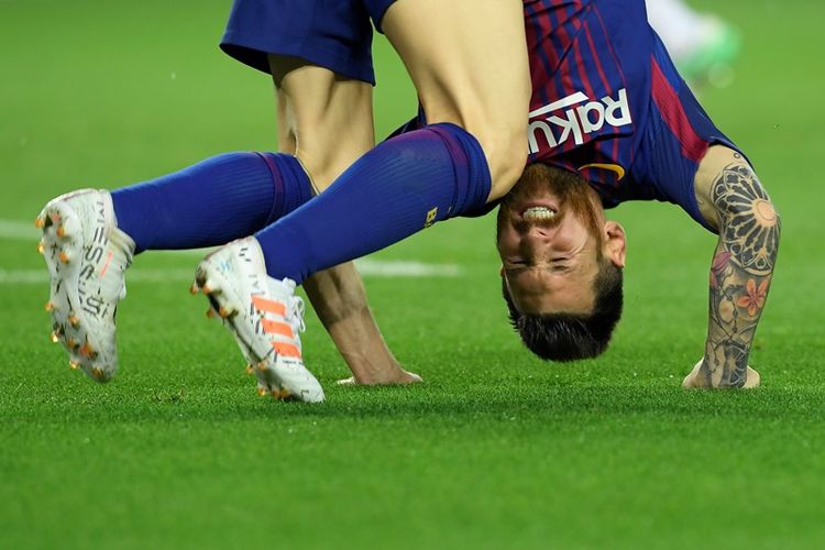 Penyerang Barcelona, Lionel Messi, jatuh ke rumput ketika timnya menghadapi Olympiacos FC dalam penyisihan Grup D Liga Champions di Camp Nou, Barcelona, 18 Oktober 2017.
