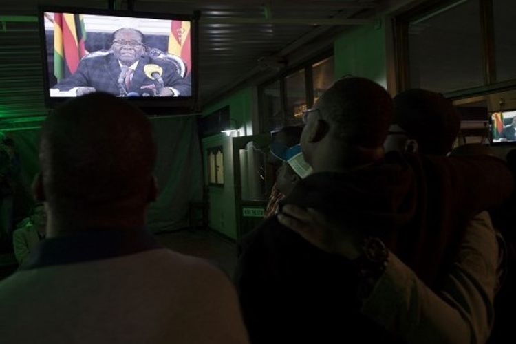 Warga Zimbabwe menonton pidato Presiden Robert Mugabe di stasiun televisi nasional. (AFP/STR).