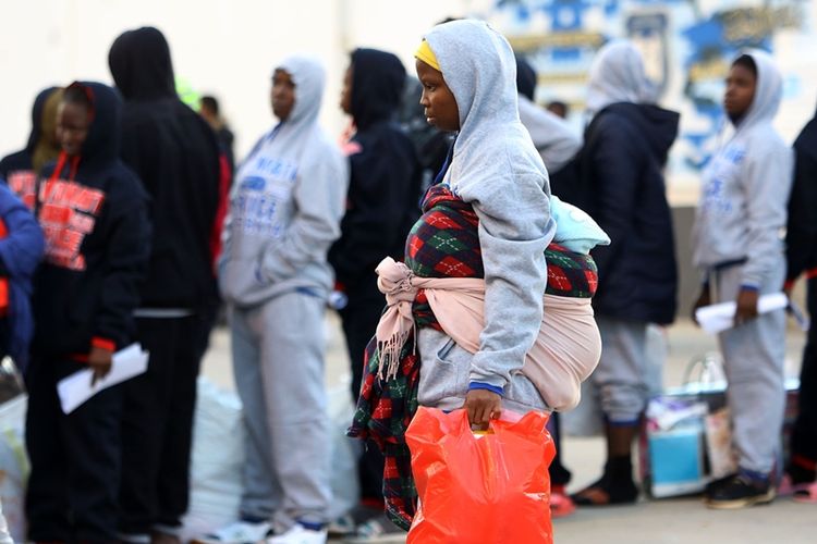 Wanita migran Afrika sedang mengantre untuk mendapat bantuan pakaian di Tripoli, Libya, pada Selasa (5/12/2017).