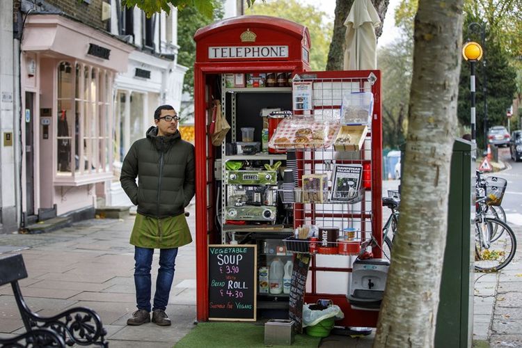 Umar Khalid berpose di luar boks telepon merah. Dia mengelola kedai kopi di Hampstead Heath, London utara. Foto ini diambil pada 20 Oktober 2017. (AFP/Tolga Akme)