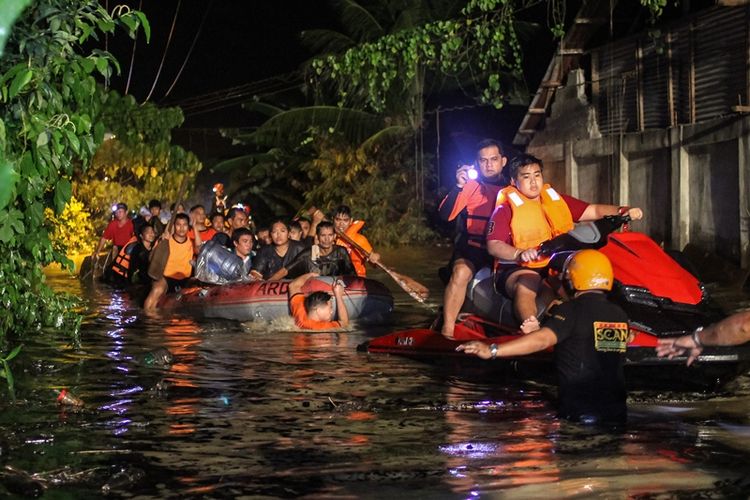 Petugas penyelamat mengevakuasi penduduk yang terkena banjir di Davao di pulau Mindanao, Filipina selatan, pada Jumat (22/12/2017), setelah badai tropis Tembin menyebabkan hujan lebat di seluruh pulau. (AFP/Manman Dejeto)