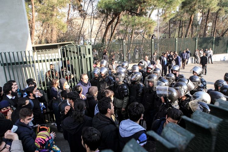 Polisi Iran berhadapan dengan mahasiswa Universitas Teheran (30/12/2017). Demo yang berawal dari memprotes kenaikan harga barang itu telah menewaskan dua warga sipil.