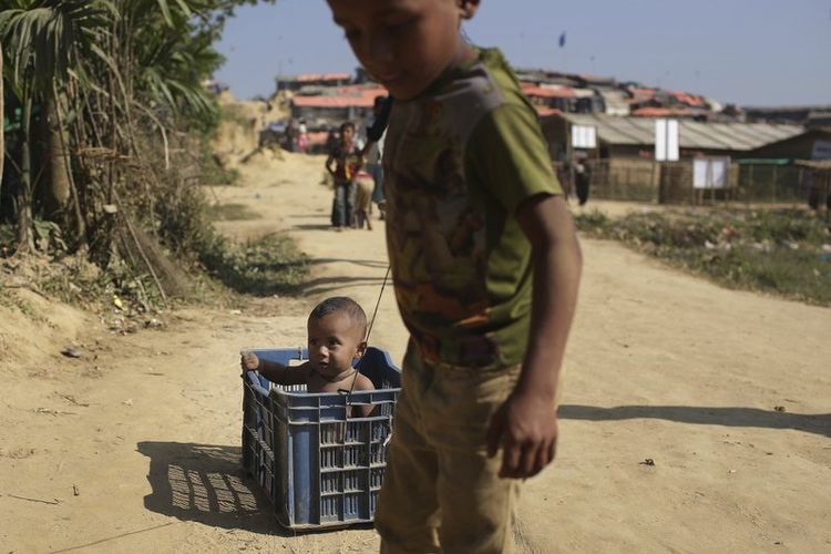 Foto ini diambil pada 27 November 2017, memperlihatkan anak-anak etnis Rohingya mengendarai mobil yang dibuat dengan peti plastik di sekitar kamp pengungsi Jamtoli di Bangladesh. (Associated Press)