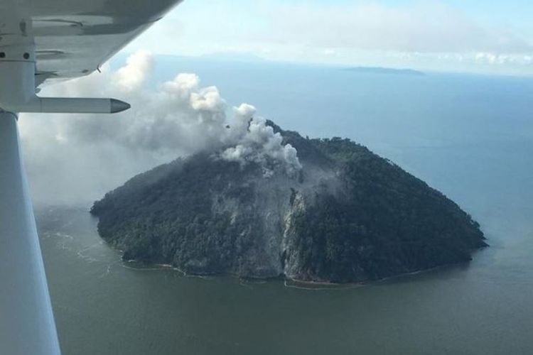 Gunung setinggi 500 meter yang diyakini tidak pernah meletus, memuntahkan asap tebal, di pulau kecil Kadovar, Papua Nugini, sejak Jumat (5/1/2018). (Samaritan Aviation via Facebook)